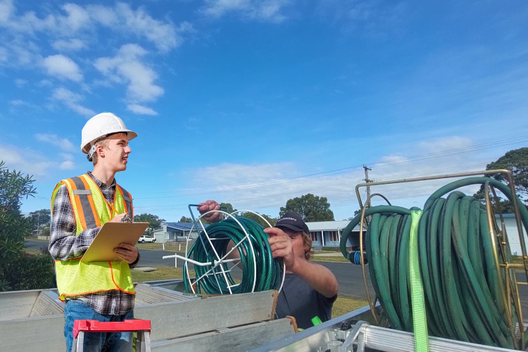
Post-rinsing, narooma gutter cleaner prepares his hose equipment for transport.